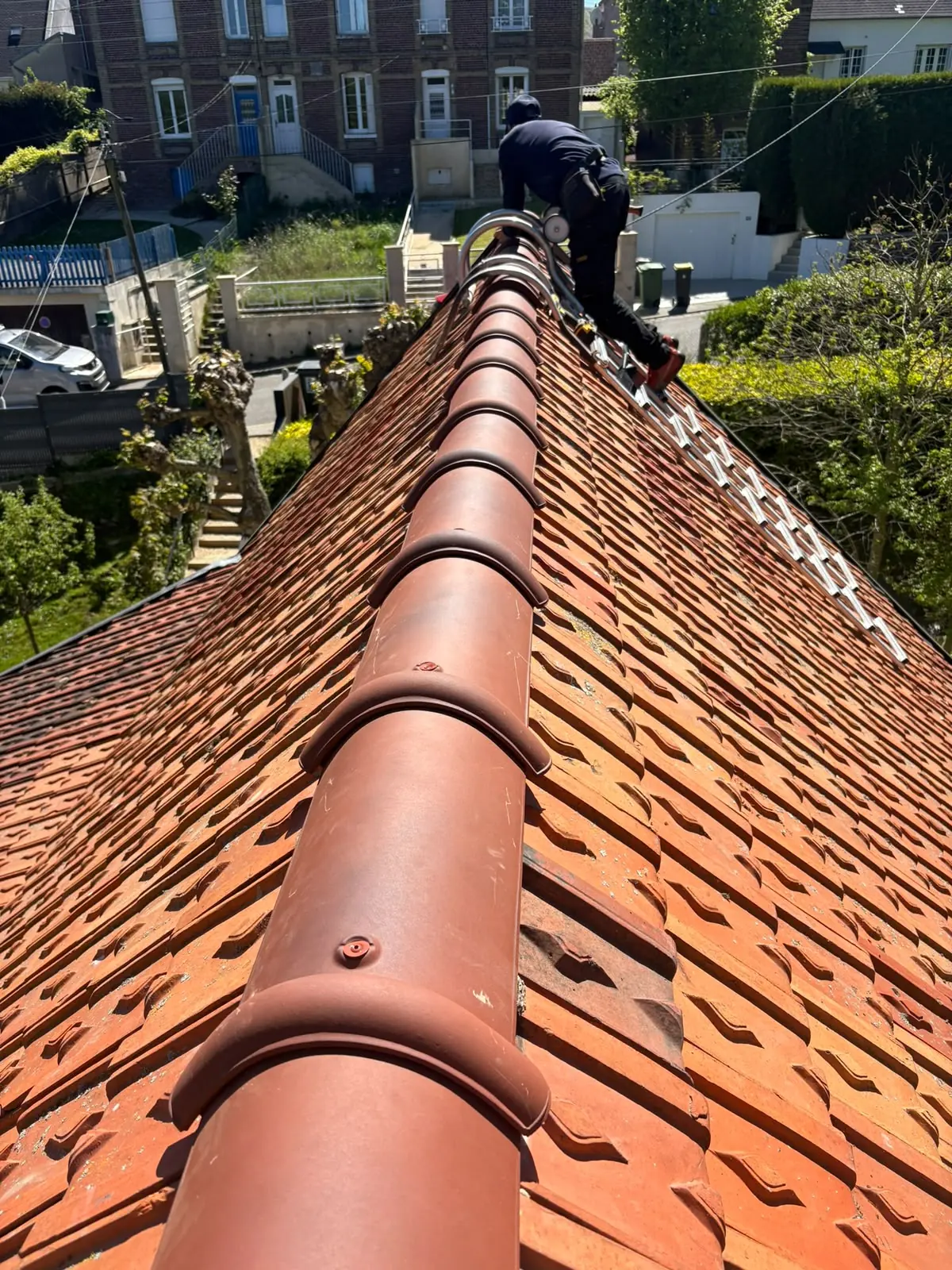 Faîtage en tuiles neuves aligné sur une toiture en tuile