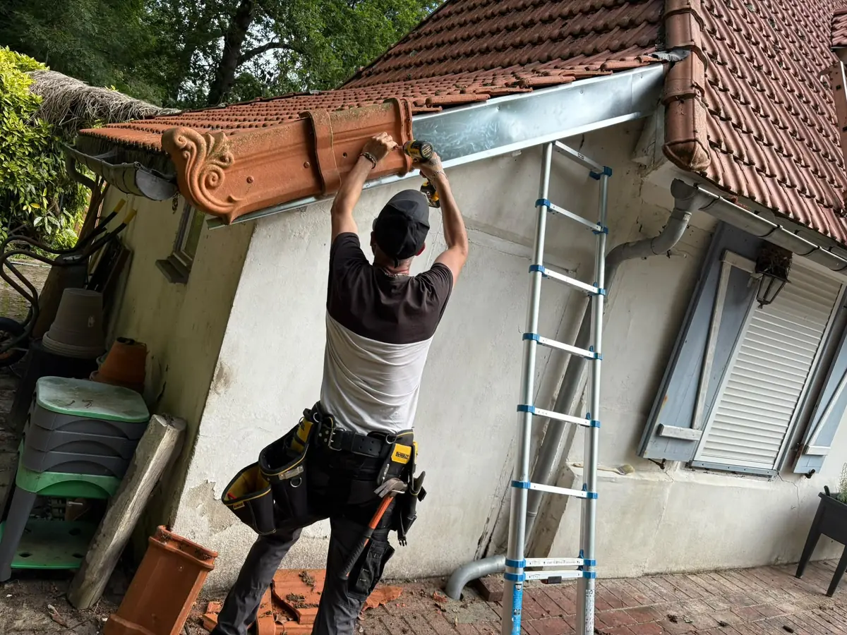 Pose d’une gouttière neuve le long d’une maison